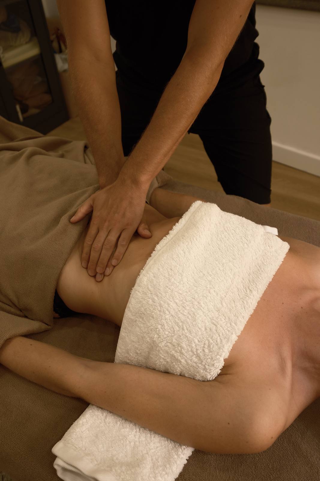 Les mains de Julien Jacquier posées sur le ventre pendant un massage Chi Nei Tsang