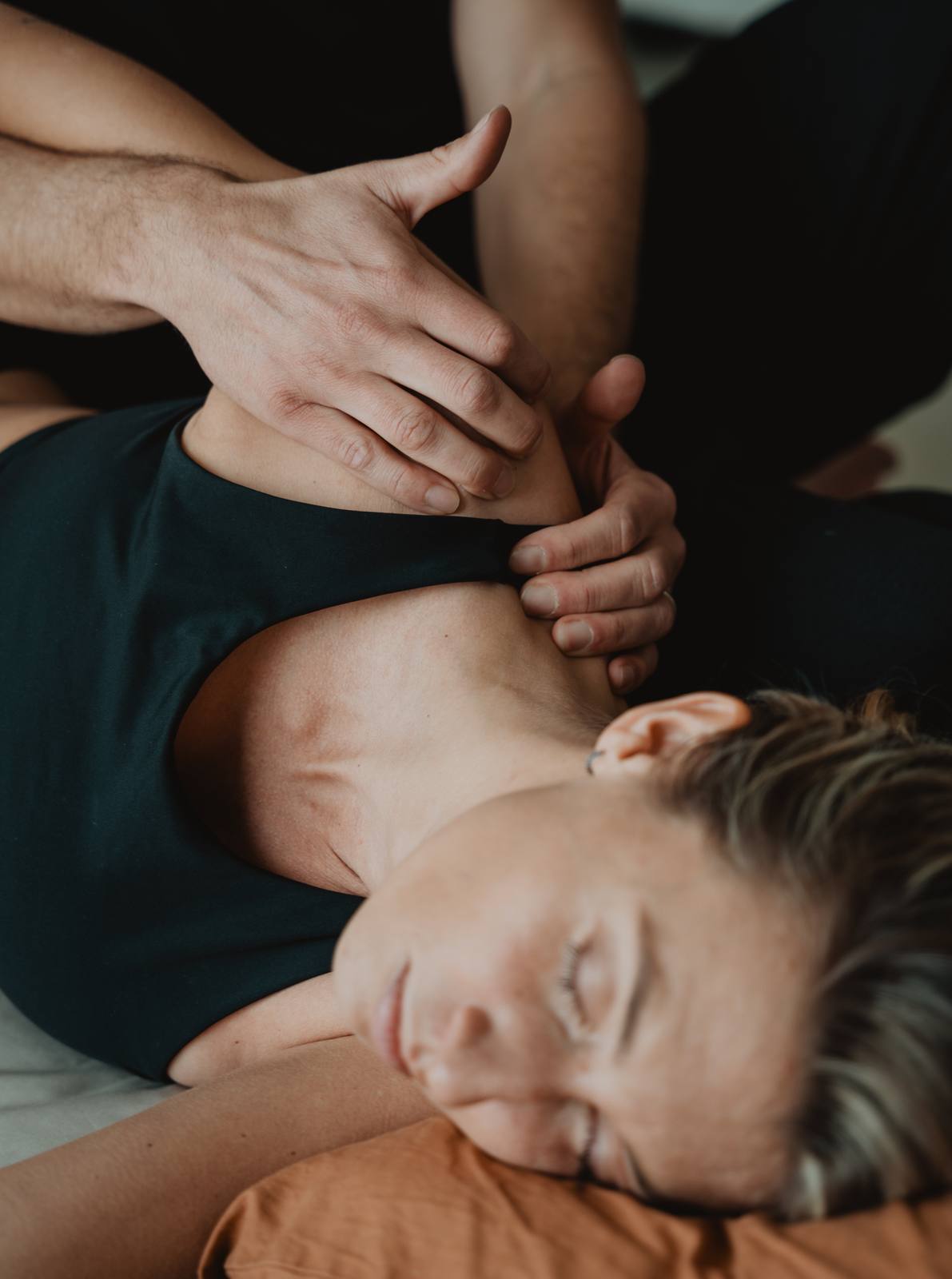 Pression lente de la main sur l'épaule et la nuque d'une personne allongée sur le côté