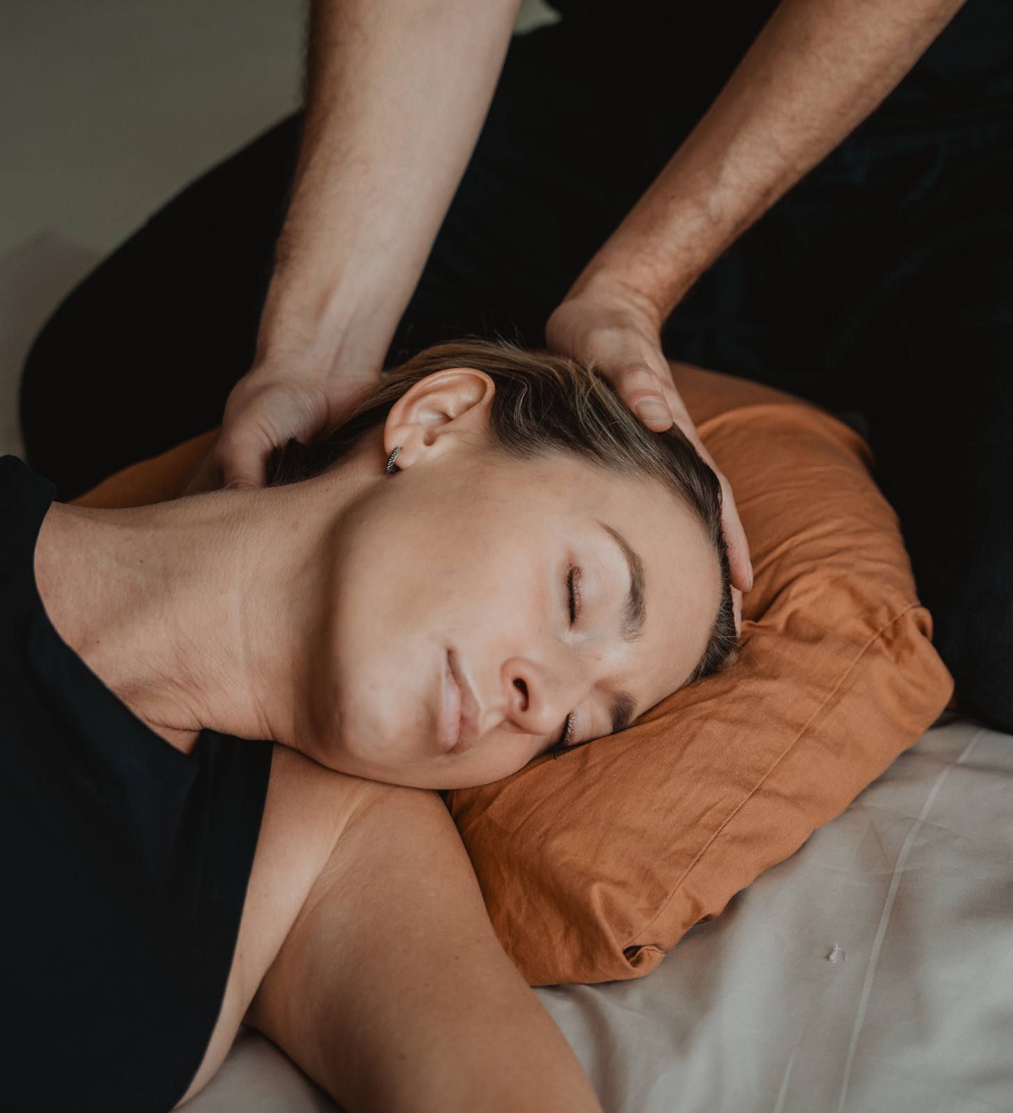Visage détendu, yeux fermés, la tête posée sur un coussin pendant une séance